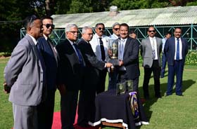Chairman of Mysore Race Club G Venkatesh presenting the Mysore 2000Guineas Trophy to trainer Pradeep Annaiah after his ward Echoes of Time won this event at Mysore on Friday.