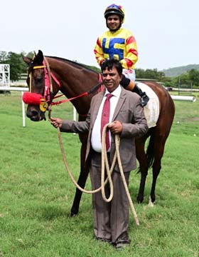 Feronia (Sah Farid Ansari up), winner of the CHAITANYA CHAKRAM PLATE (DIV-II) being led in by trainer Rakesh on Wednesday races at Mysore.