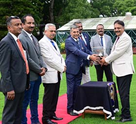 Member of the Managing Committee of the Mysore Race Club Gautam Basappa presenting the Chevalier Trophy to trainer K S Mandanna who ward Vandhiyathevan won this event at Mysore on Wednesday.