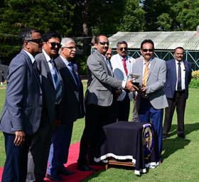 Member of the Managing Committee Dr Venu presenting the Dr M A M Ramaswamy trophy to trainer Monnappa after Aashirvad won this event at Mysore on Thursday.