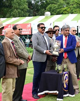 Chairman of Mysore Race Club K T Balakrishna presenting the Mysore 2000 Guineas Trophy to trainer Prasanna Kumar whose ward Stud Poker won this event at Mysore on Thursday